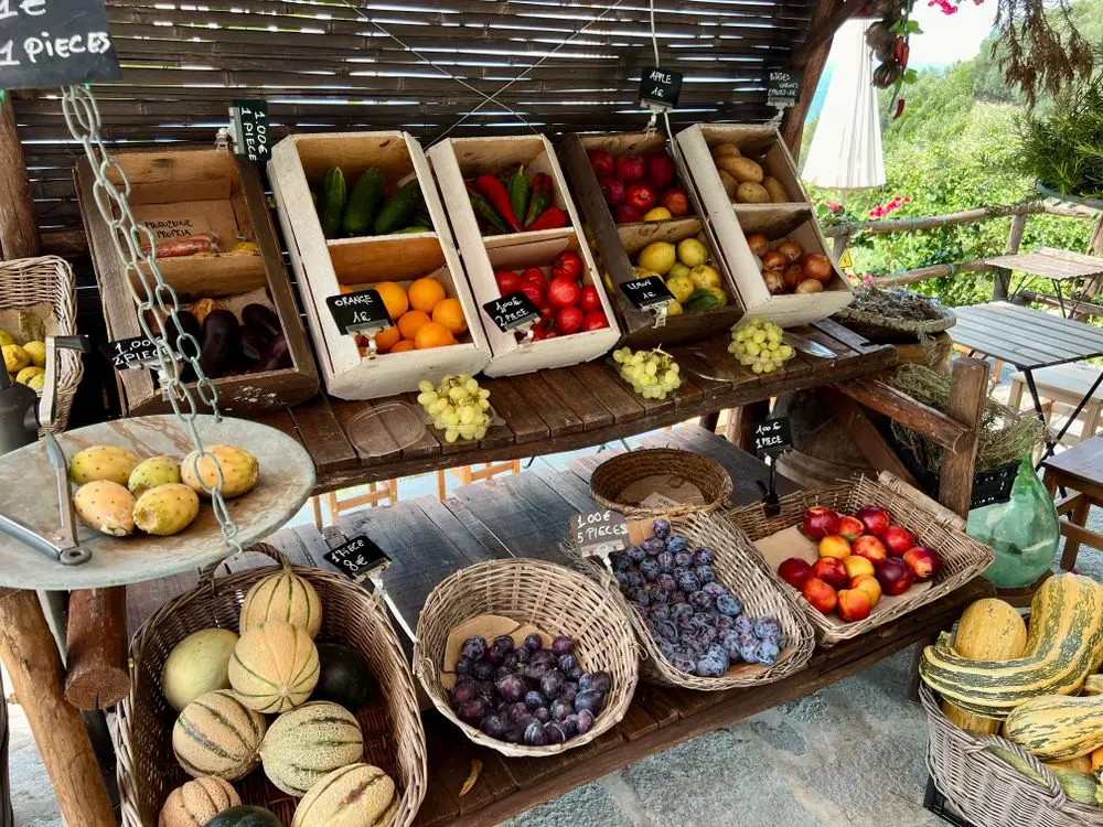 Étal de fruits et légumes de saison en cagettes et paniers