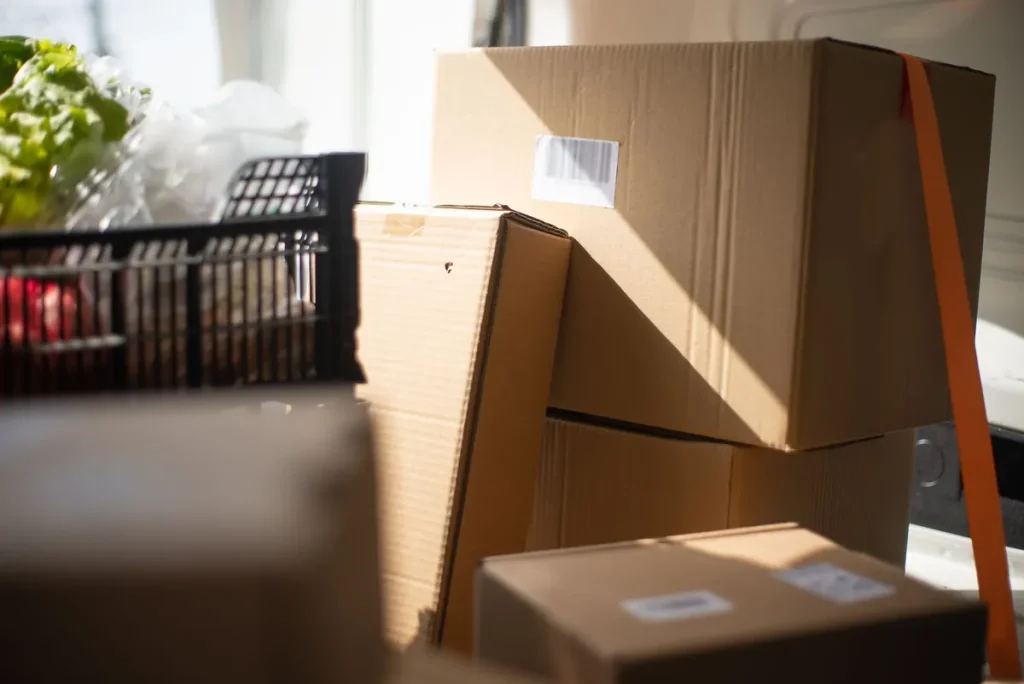 Cartons de livraison et caisse de légumes frais dans un utilitaire