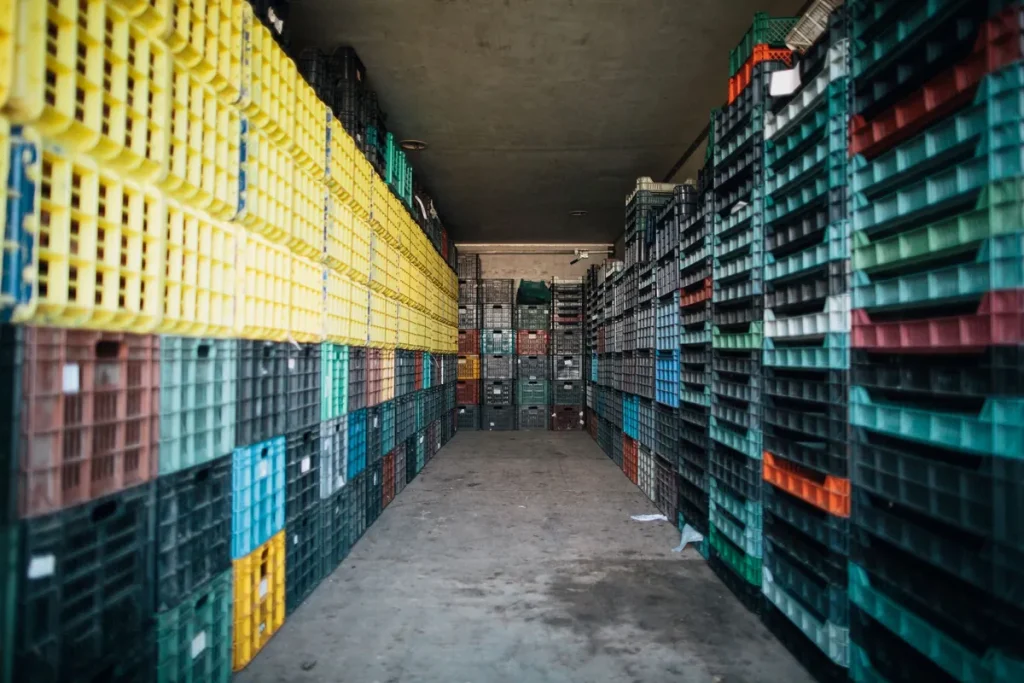 Allée de caisses en plastique empilées dans un entrepôt de stockage